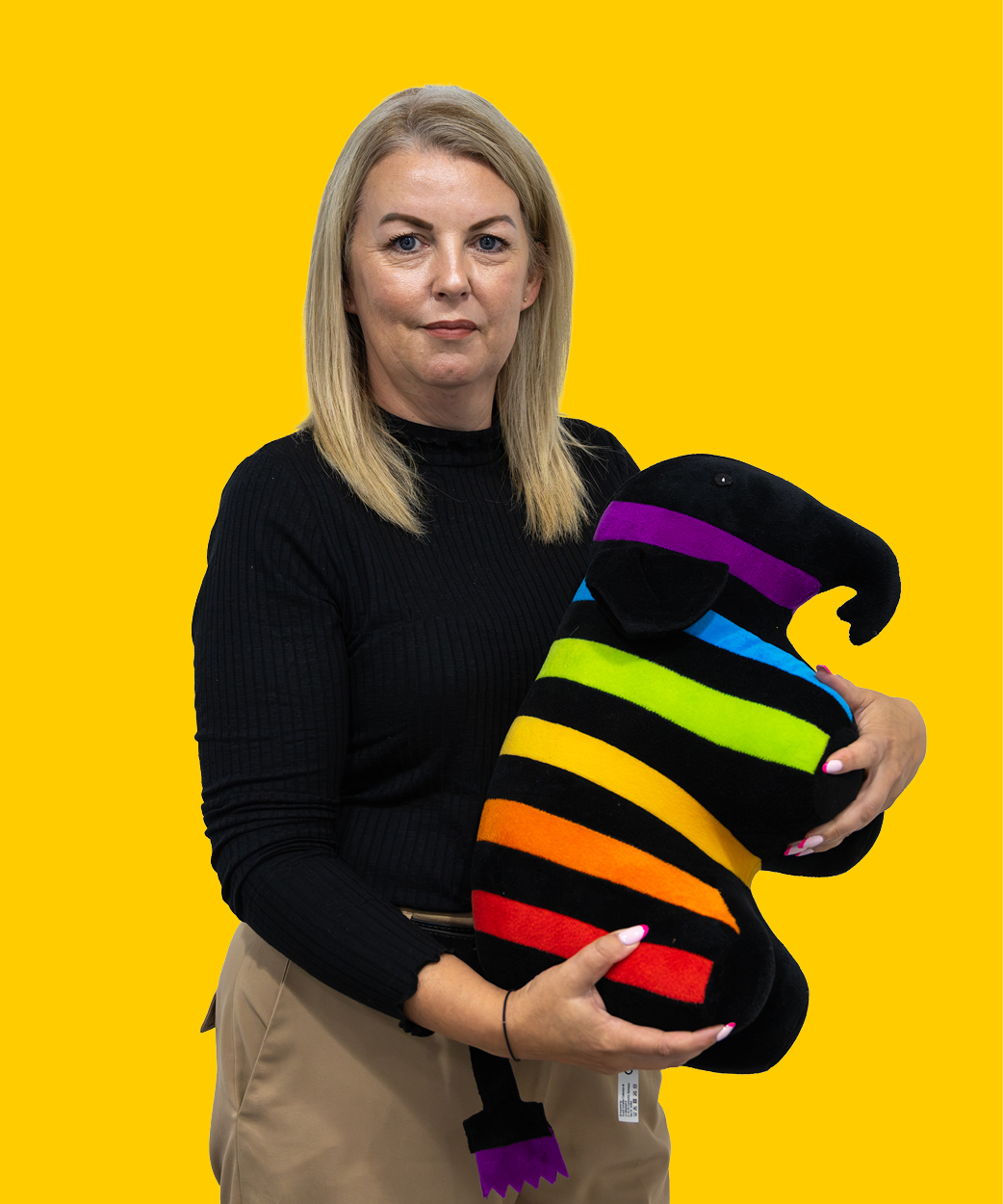 emma holding a caparol elephant on yellow background